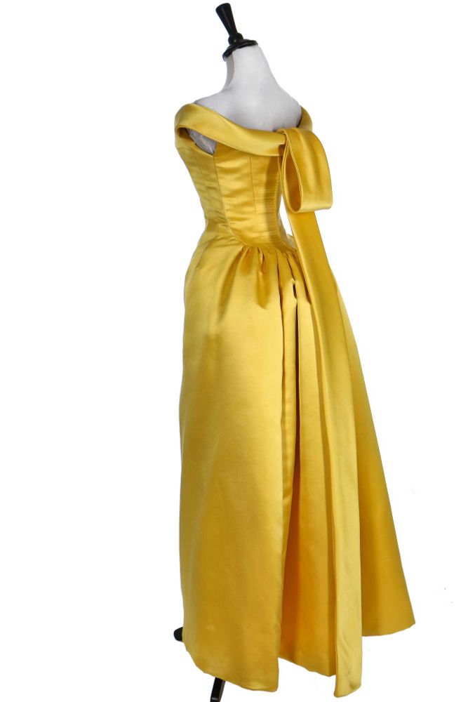 Full length view of the back of the Balenciaga yellow dress showing the sculptural construction including the long loop centre back