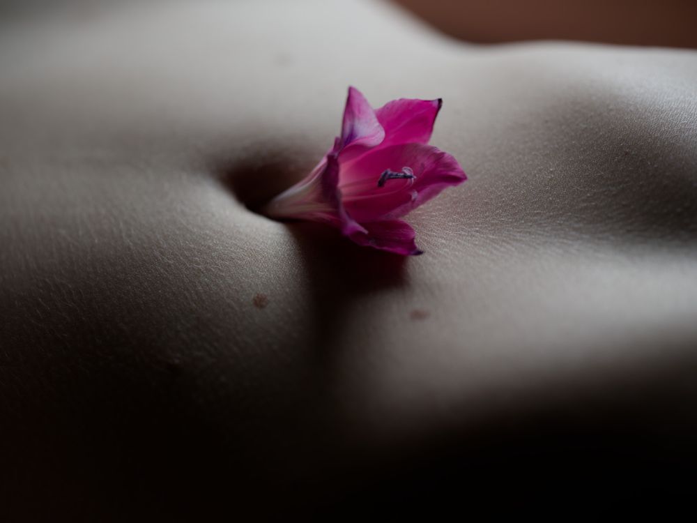 red flower in a woman's belly button