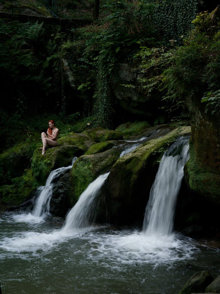 A woman at a forest waterfall 
