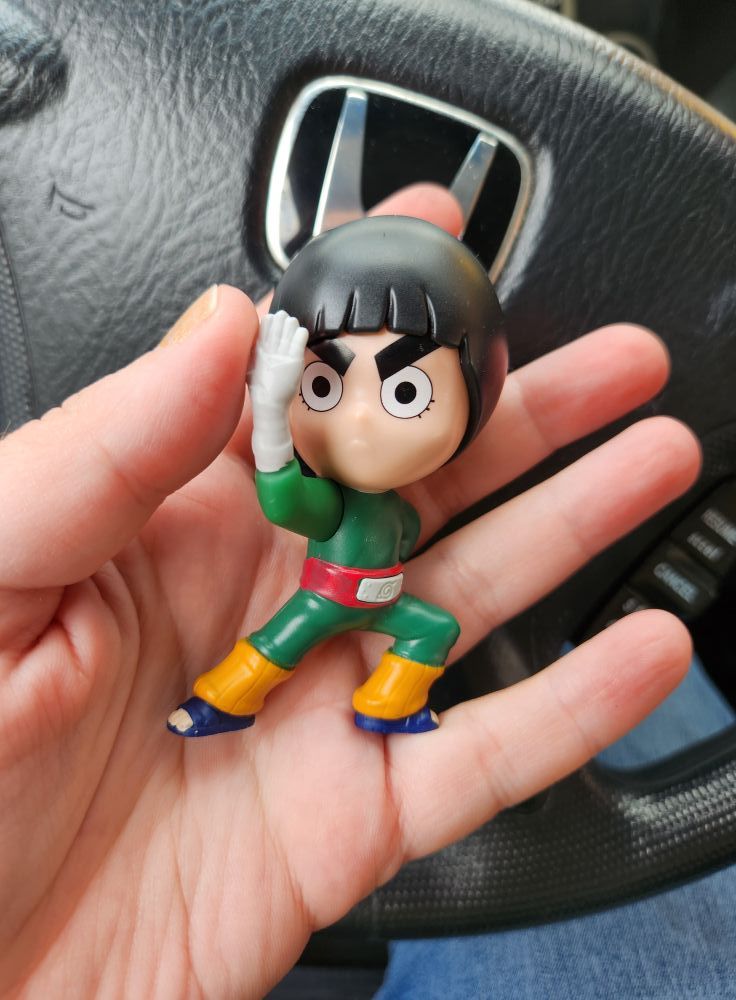 A plastic toy of Rock Lee from Naruto.