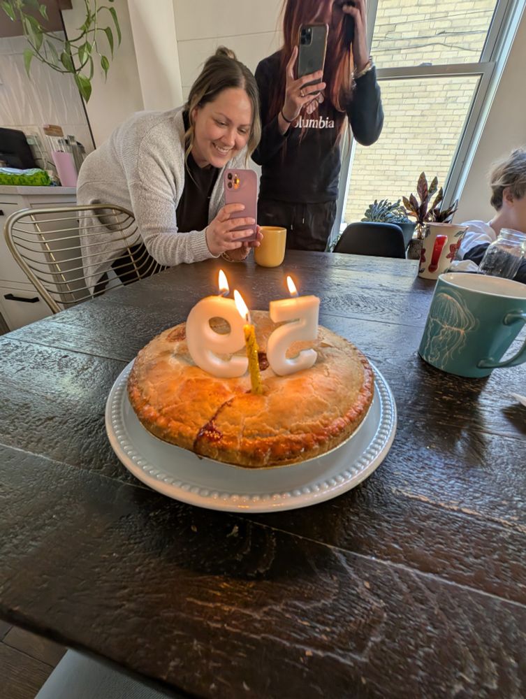 Birthday apple pie at the end of a birthday brunch at my son's. My daughter in law and daughter S taking a photo of the pie. 