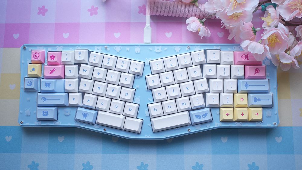 Pan themed keyboard and deskmat in pink, yellow, and light blue.