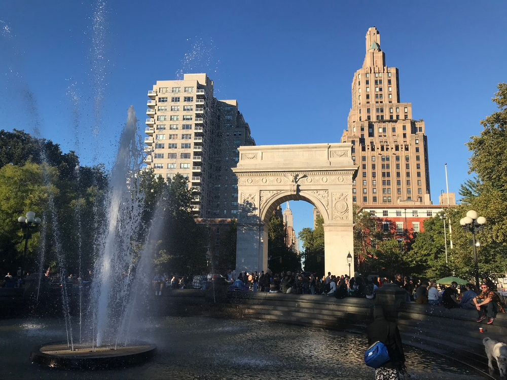Looking north at the Washington Square Arch, with 1 Fifth avenue behind it and a fountain in front of it. NYU Biology is a block to the right from this scene, on Washington Square East.