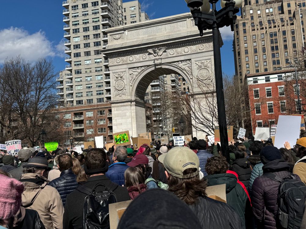 100s of people at the Stand up for Science rally in Washington Square Park. They’re holding signs in front of the Wash Square arch