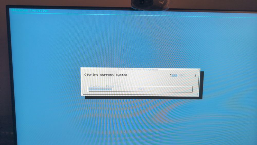 Picture of a screen monitor. The screen shows the OPNSense Installer at the step of cloning the system from the USB stick to the internal storage. The global progress is at 24%