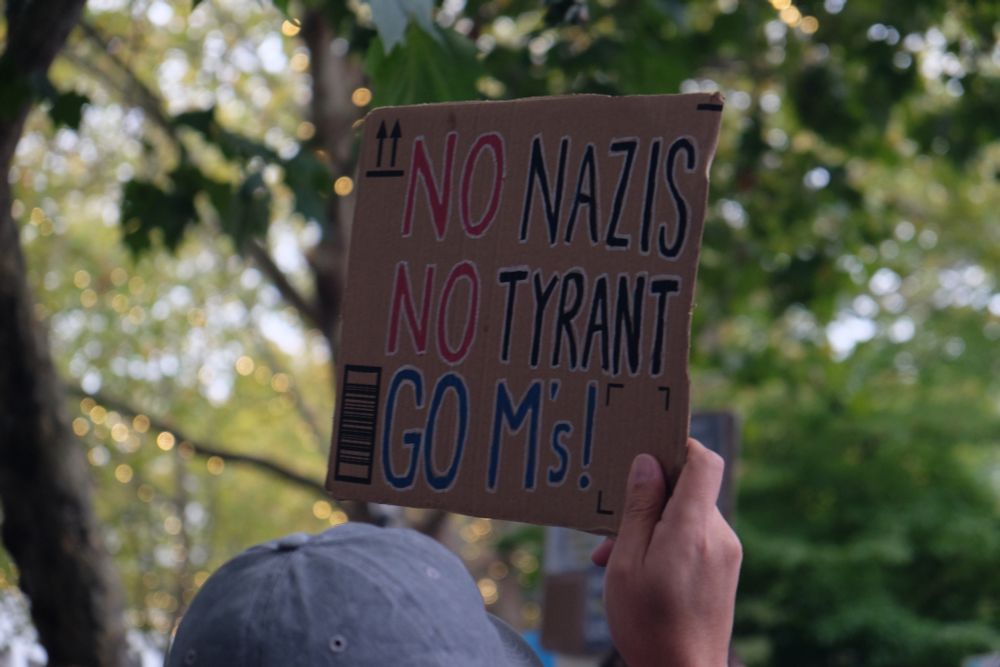 A very Seattle protest sign reading "No Nazis, No Tyrant, Go M's!"