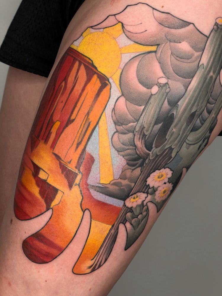 A tattoo depicting a saguaro cactus and a desert scene.