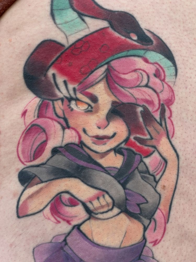 A healed tattoo depicting a femme character with a snake emerging from their left eye.