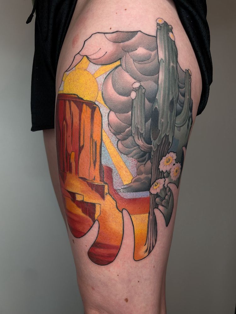 A tattoo depicting a saguaro cactus and a desert scene.