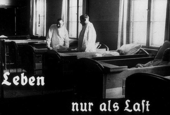 Still from a black and white Nazi propaganda film showing two doctors working on a hospital ward