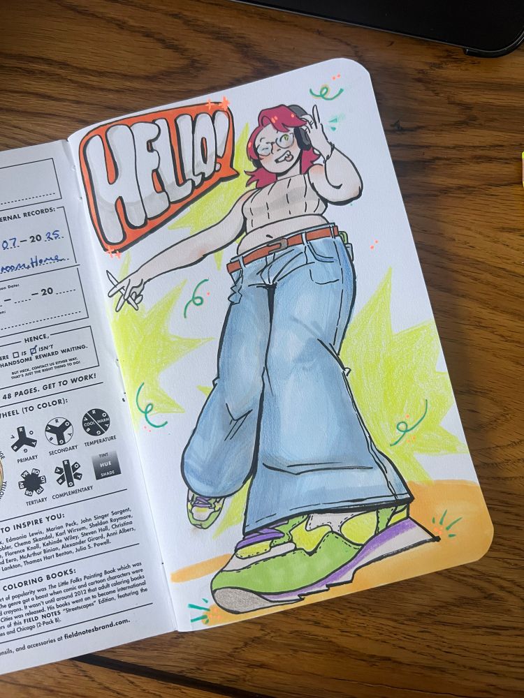 Photo of a sketchbook with a cartoony and colourful self-portrait of the artist in cool green shoes. A speech bubble says “HELLO!”.
