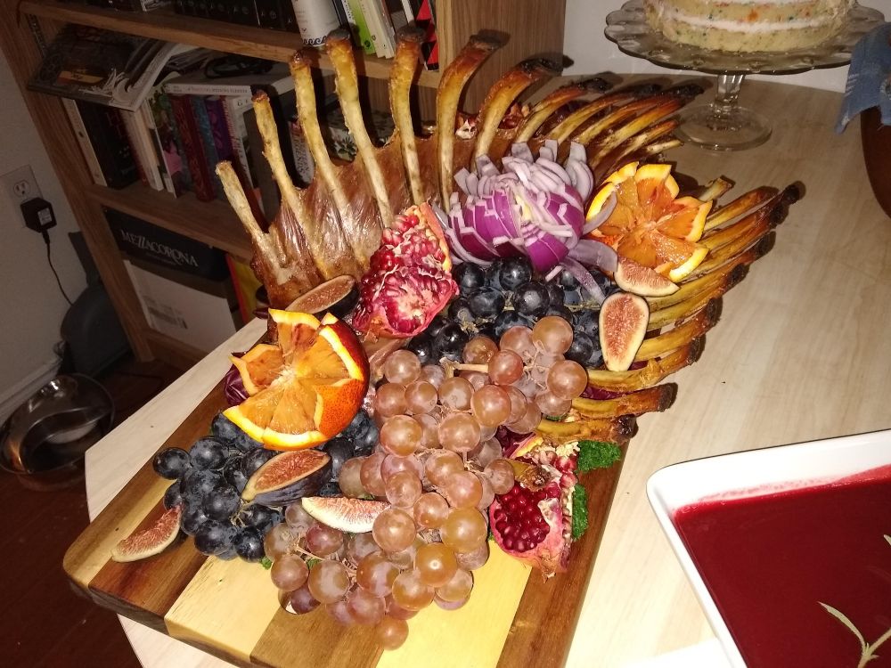 A roast of lamb where the entire ribcage is filled with fruit, making a sort of macabre cornucopia. Besides it is a bowl of blood red Cumberland sauce.