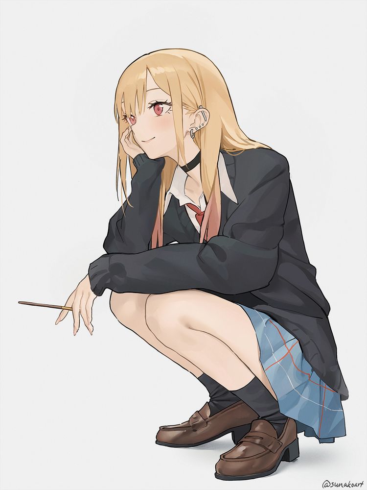 Marin squatting down in a relaxed pose, smiling and holding a pocky snack