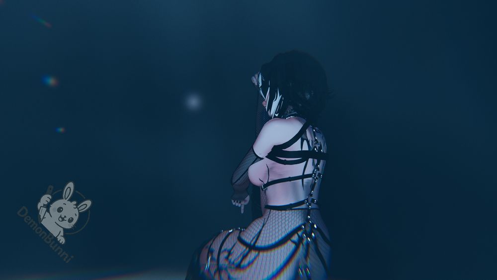 Photograph of a woman with black and white hair, wearing a black harness and fishnet clothing, kneeling and looking up at a bright light. The "DemonBunni" logo is in the lower left corner.