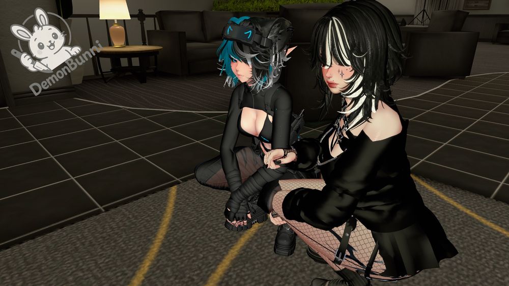 Photograph of two anime-style avatars crouching on a black tiled floor. The avatar on the left has blue and white hair, pointed ears, and wears a black outfit with cutouts. The avatar on the right has black and white hair, pointed ears, and wears a black dress with fishnet stockings. A logo with a bunny holding a knife and the text "DemonBunni" is in the upper left corner. In the background are black couches and a small table with a lamp.