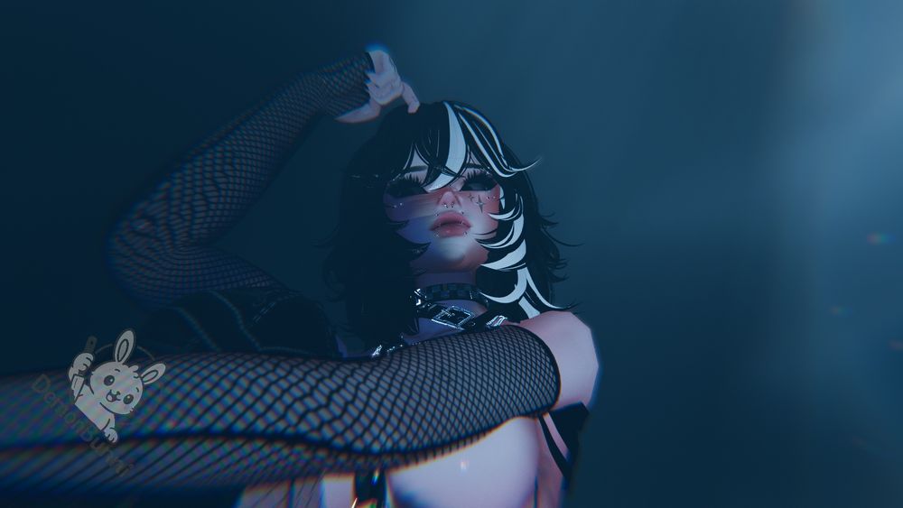 Photograph of a person with black and white hair, wearing fishnet sleeves, and a studded collar. They have piercings on their face and star-shaped makeup. A logo of a bunny holding a knife is in the lower left corner.
