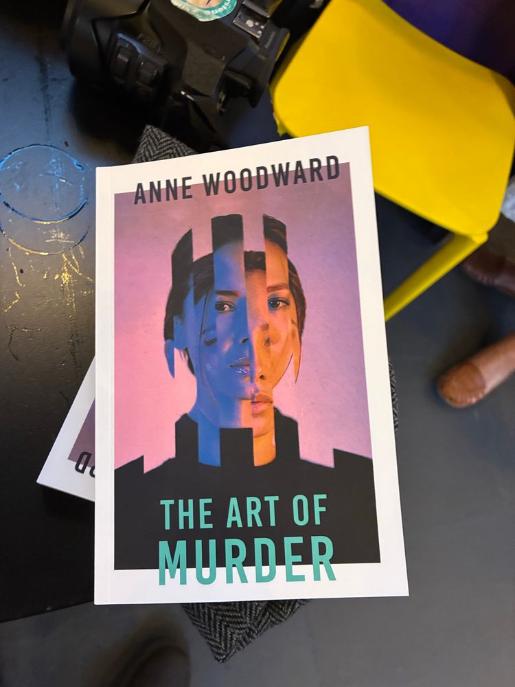 Book cover showing woman tessellated with shoulders like castle ramparts. Book called The Art of Murder. 