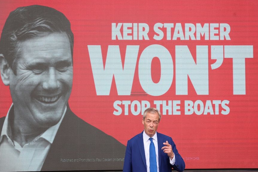 A billboard with a photo Keir Starmer giving a smarmy smile, next to the words “Keir Starmer won’t stop the boats”. In front of the billboard stands Nigel Farage, looking like twat as usual.