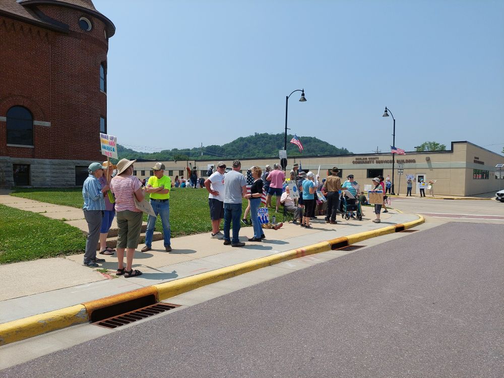People holding sign next to the street