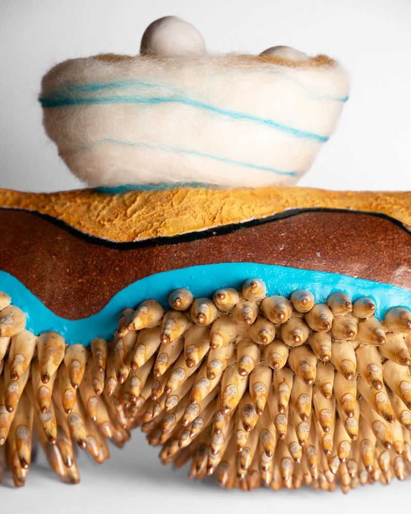 A detail shot of the many legs, stripes, and needle felting.