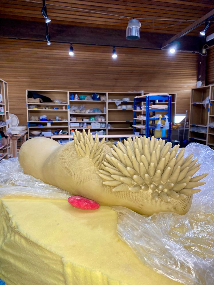 A sculpture in progress: spikes covering about 1/5 of a worm-like creature