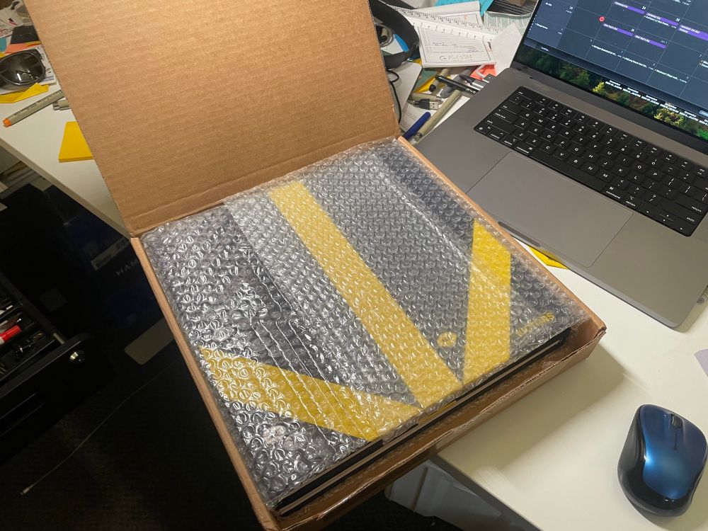 An open box containing MGoBlog’s three-yearbook Victors. The cover resembles the Michigan football helmet, Team 144’s football sticker is Maize. The book is beautiful. 