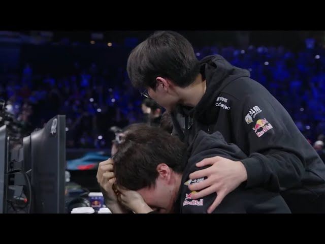 After losing game 5 of LoL Worlds Finals in 2022, T1 support player Keria is bent over at his position on stage, head in hands, weeping uncontrollably. Faker bends over him, a hand on his shoulder, trying to comfort him. 