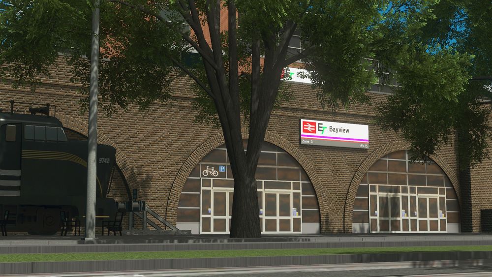 One of Bayview Station's entrances, with doors and windows embedded within a viaduct arch. A Baldwin RF-16 locomotive peeks out from the left hand side of the image.