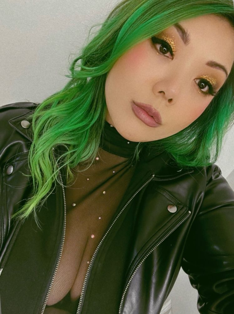 A selfie of kimb with green hair and a leather jacket 