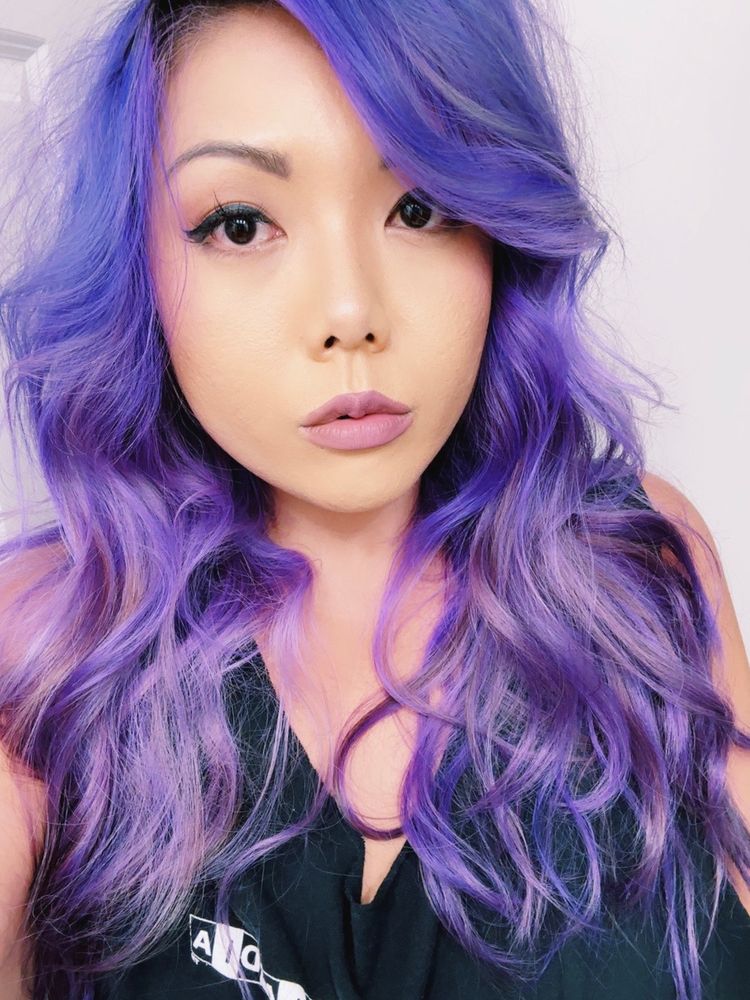 Kimberly with purple grimacé hair in loose curls around face. 

Wearing a black tank top in the bathroom. 
