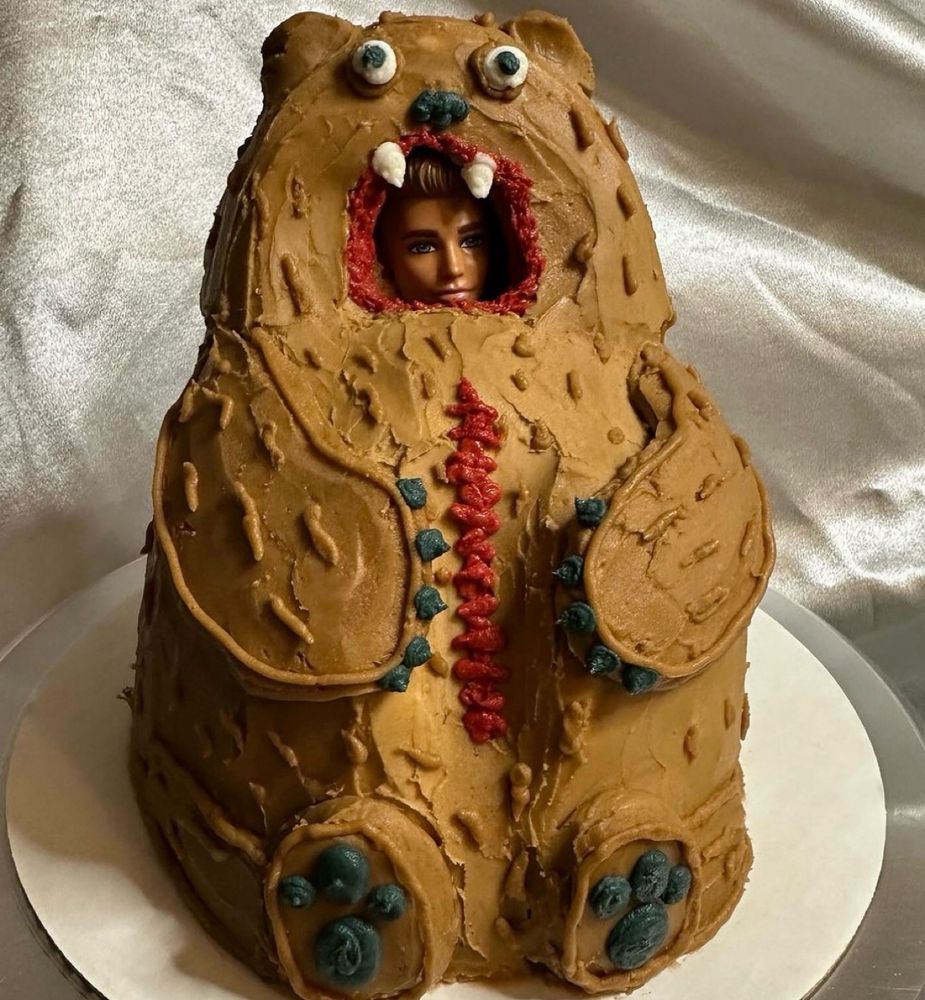A cake of a Ken doll in a bear suit made of cake a la Midsommar from cakenbaketx on instagram