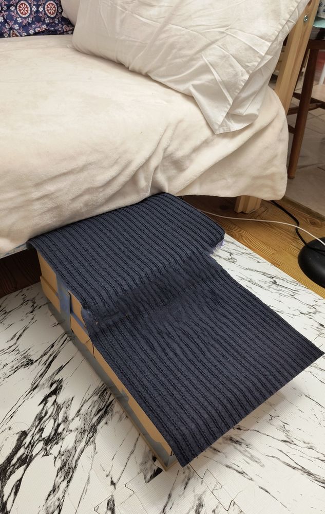 Cardboard boxes covered with scratchy fabric glued together to form steps