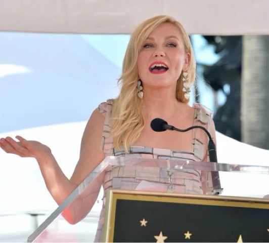 Kirsten Dunst at a microphone 