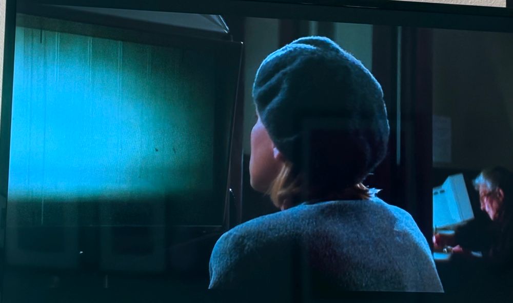 Sharon Stone investigates by using a microfiche in Sliver
