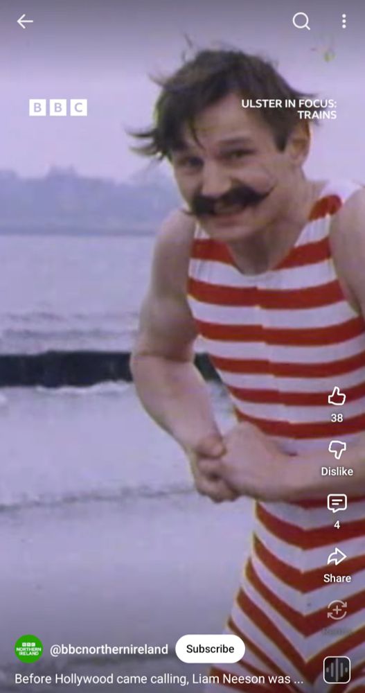 Liam Neeson in an Irish travel series wearing a red striped bathing suit
