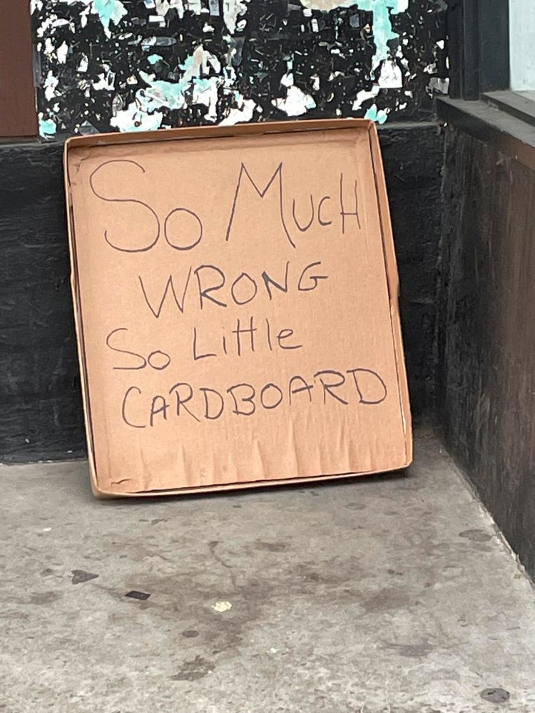A cardboard sign left behind after a #handsoff rally in Northampton, MA that says "So much wrong, so little cardboard"