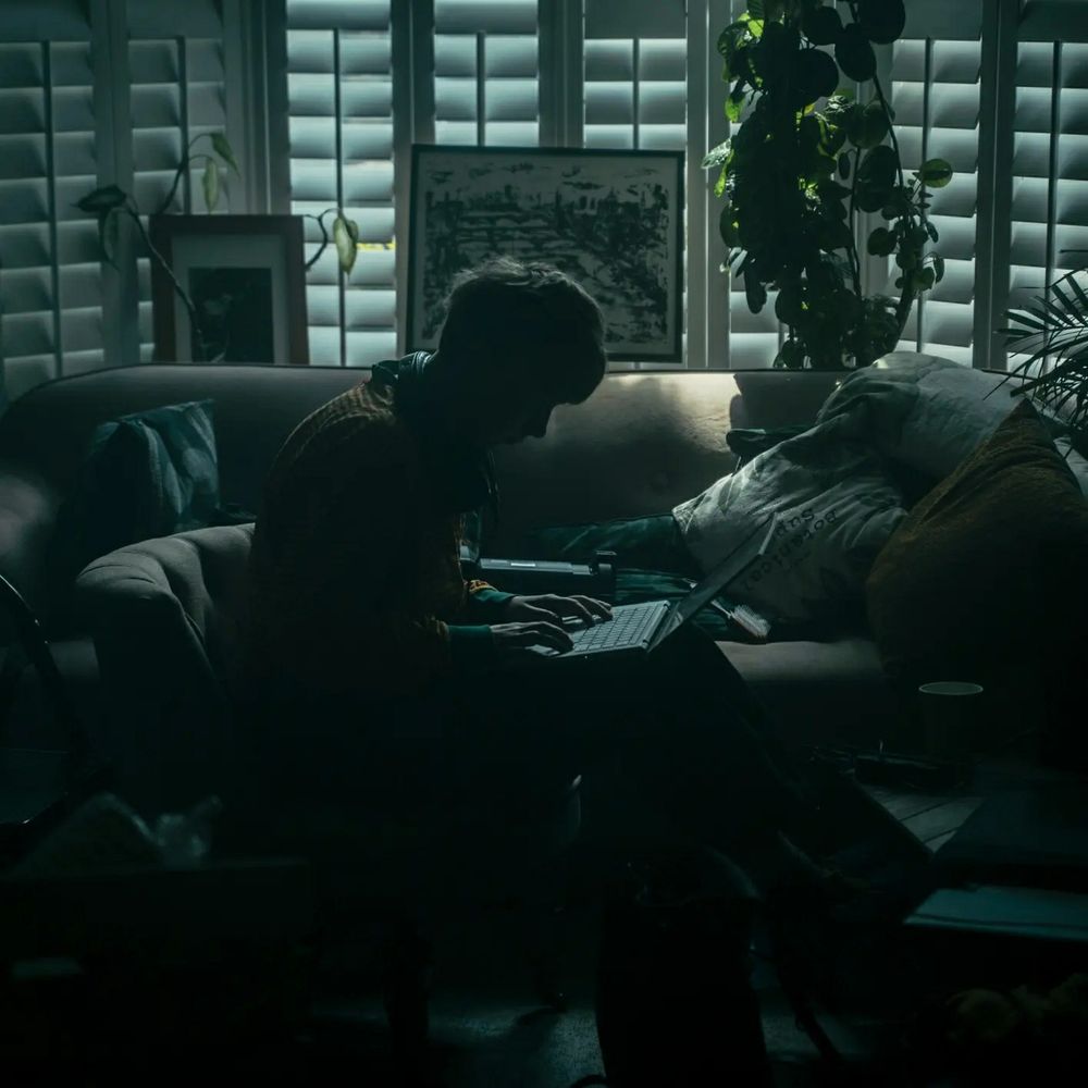 In a darkened room, a script supervisor makes notes on his laptop.