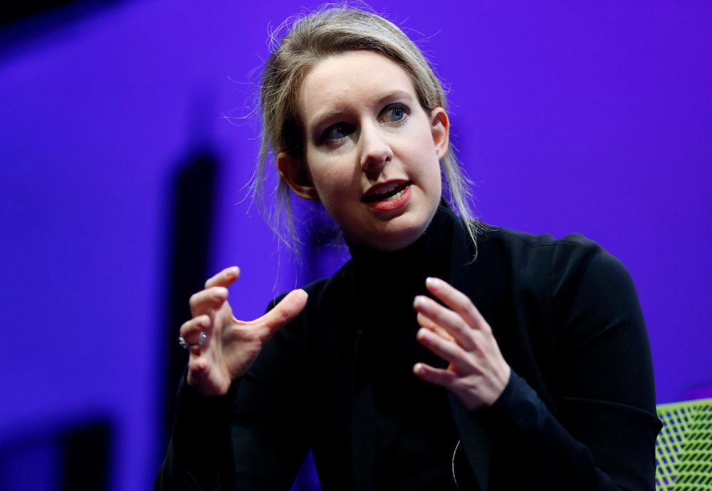 Elizabeth Holmes speaks while holding her hands about a foot apart, mid gesture