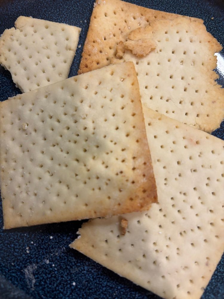 Delicious-looking home-made gluten-free matzah squares on a navy blue plate