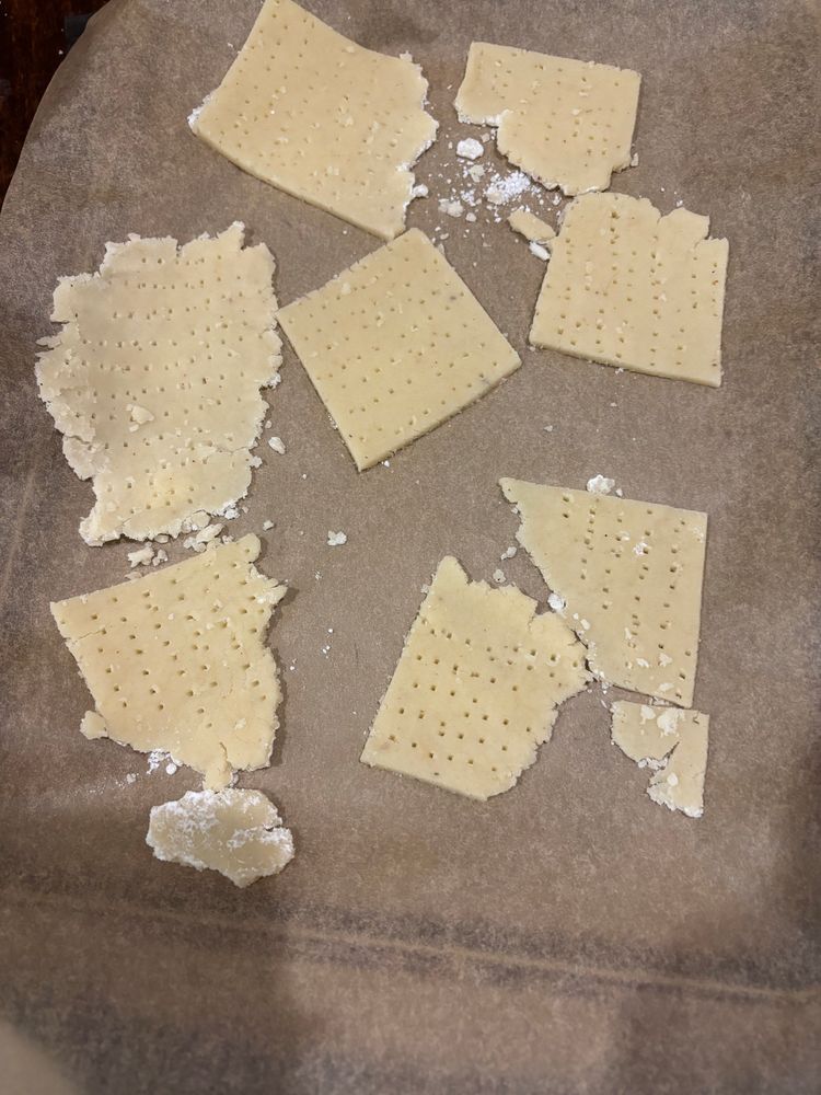 Uncooked matzah dough on a tray lined with baking paper 