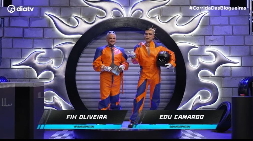 Edu e Fih, apresentadores do corrida das blogueiras vestidos de macacao laranja e azul. 