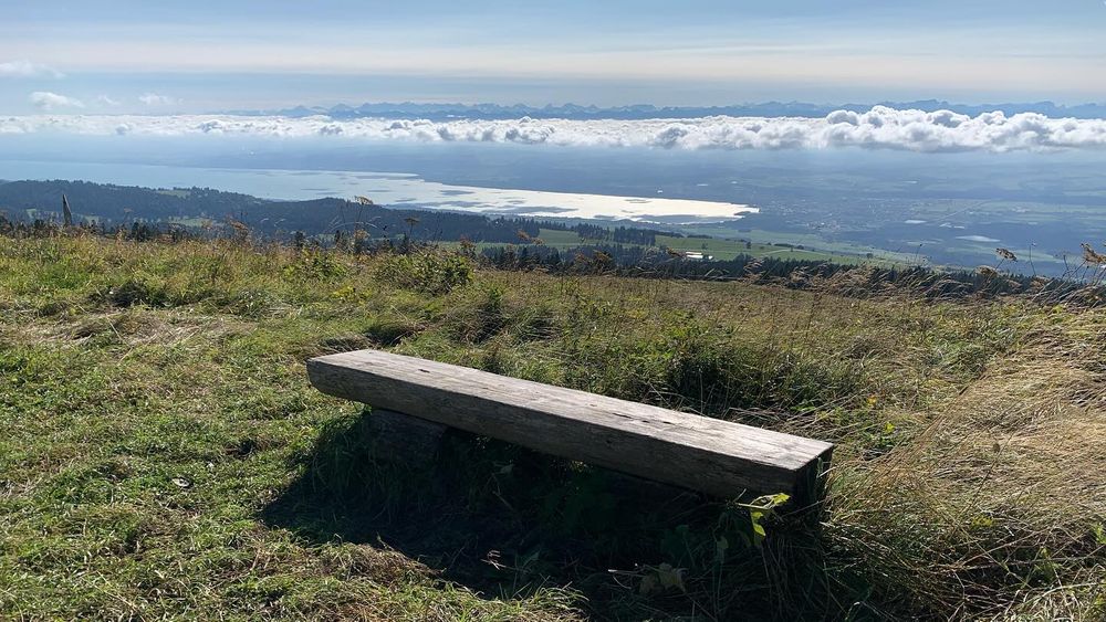 Das Bild zeigt einen atemberaubenden Blick vom Chasseron im Jura-Gebirge, hinunter ins Schweizer Mittelland. Der Blick reicht weit über Felder, Wälder und Siedlungen hinweg bis hin zum glitzernden…