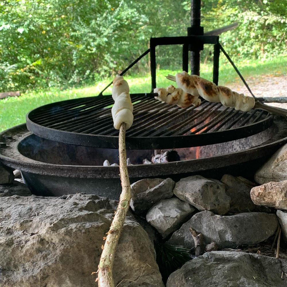 Gemütliches Outdoor-Feeling mit frischem Schlangenbrot über dem Feuer 🍞🔥! Gibt’s etwas Besseres als den Duft von frisch gebackenem Brot in der Natur? 🌿✨ #schlangenbrot #campingvibes #outdoorcooking…