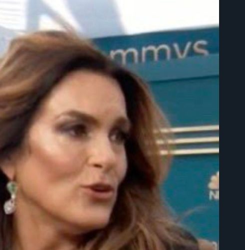 A close up of mariska hargitay at the 2022 Emmys. Behind mariska, there is an emmy's sign where only 'mmys' is visible.