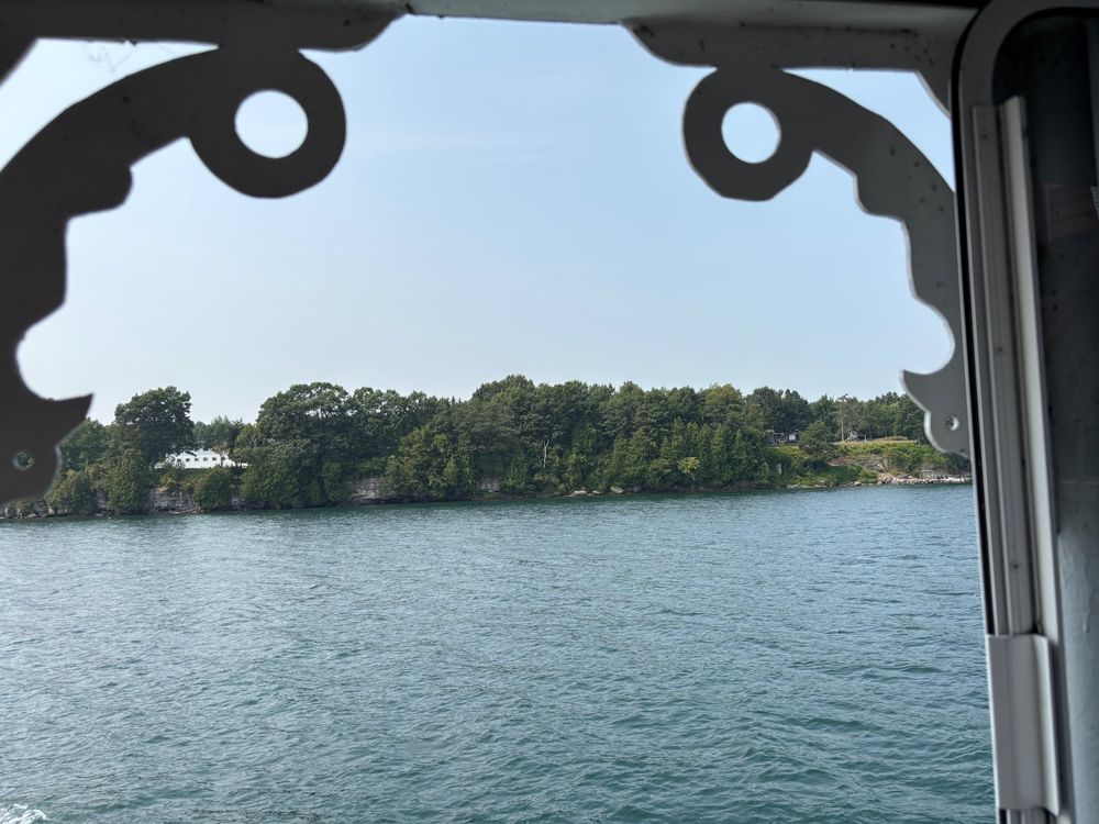 Water with an island in the background, seen though a window 
