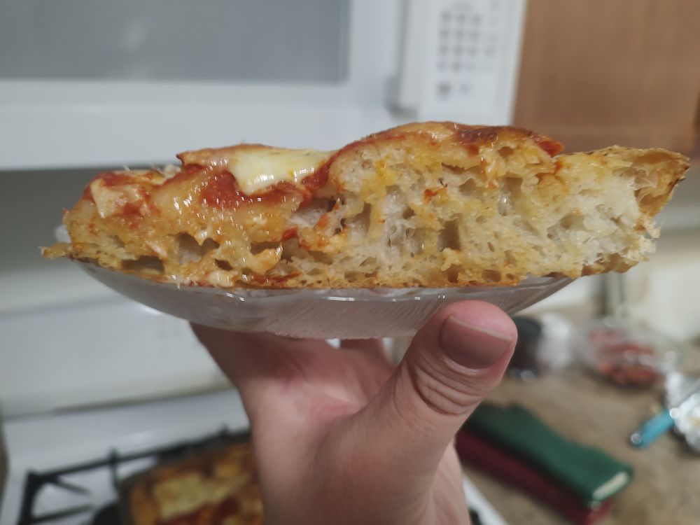 side view of a slice where you can see that it's about an inch thick and has an open crumb structure like a sourdough