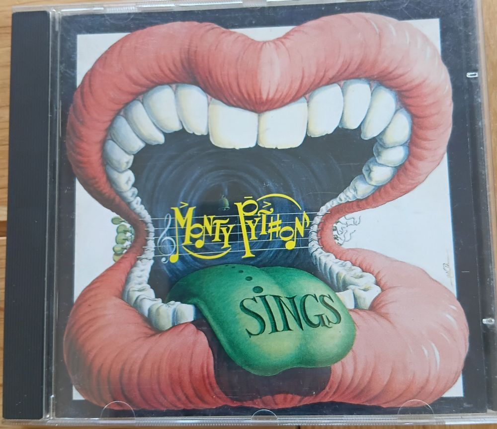 Monty Python Sings CD box. The picture is a large cartoon mouth with red lips and a green tongue.