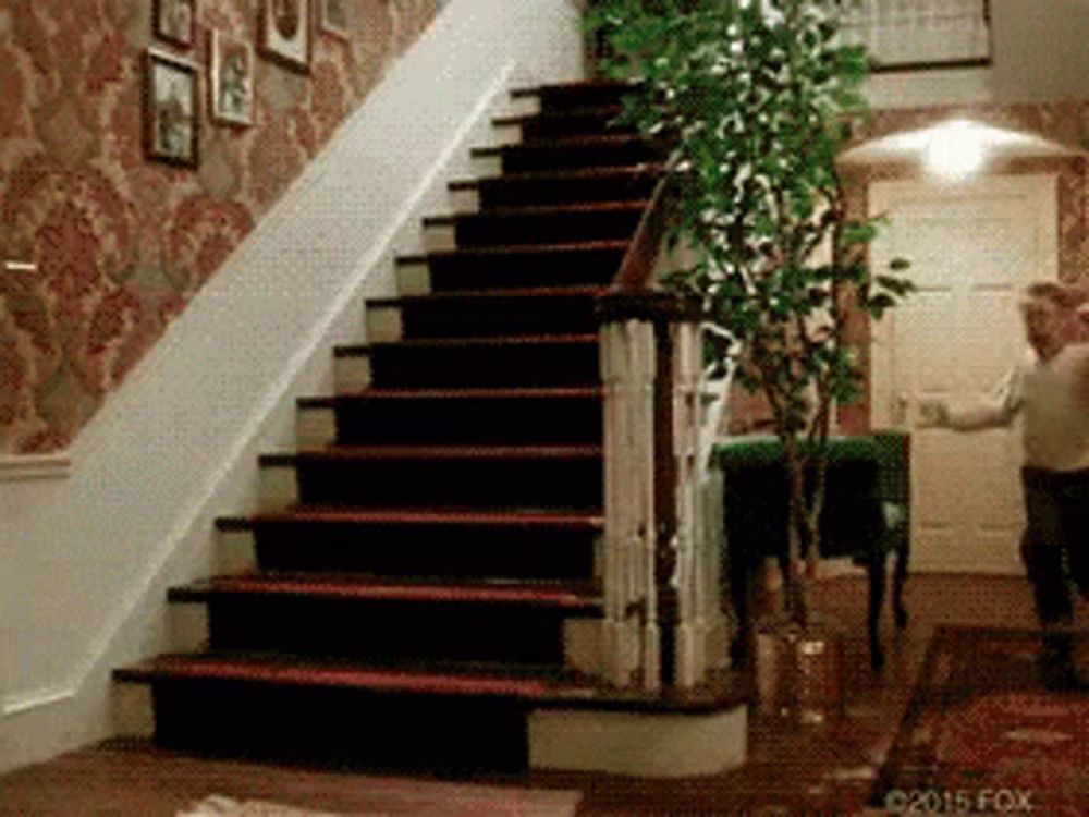 a man is walking down a set of stairs in a home