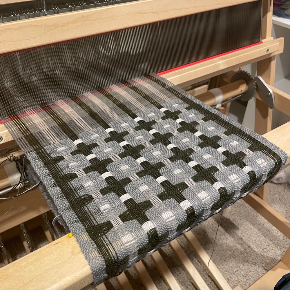 Deflected double weave fabric in shades of gray on a floor loom.