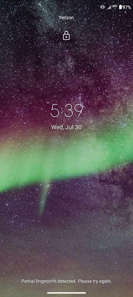A screencap of my phone's lock screen. It merely shows the date and time over a field of stars in the night sky, with the aurora borealis cutting horizontally across the screen in a green stripe.

Small text at the bottom reads that it only got a partial read of my fingerprint. This is because I wasn't TRYING to UNLOCK THE PHONE.